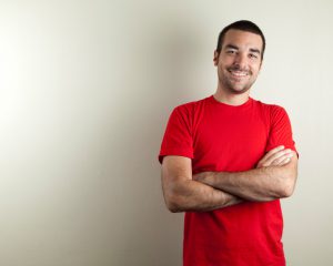 "An ordinary man with red t-shirt on beige background, smiling. Copy space."