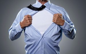 Young businessman tearing his shirt off isolated on gray background with copy space